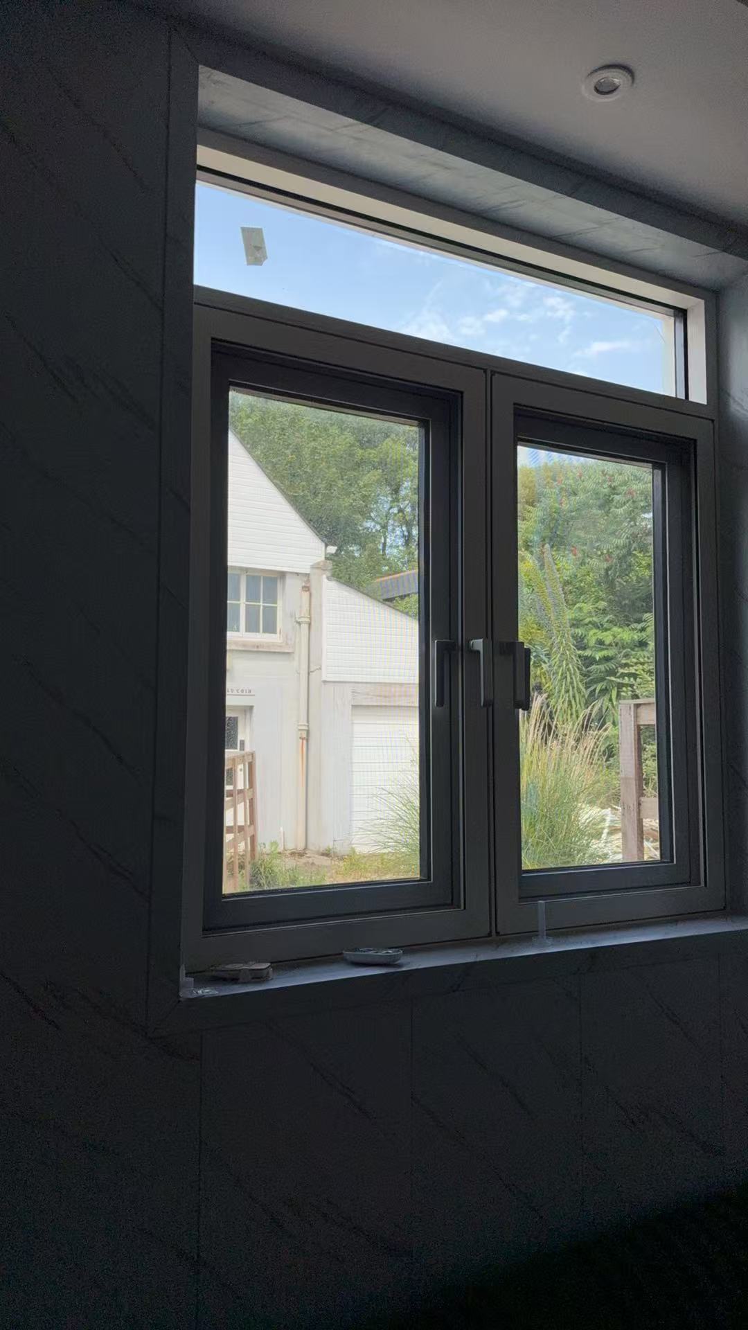 White casement windows with garden view for a Jersey Island residential project